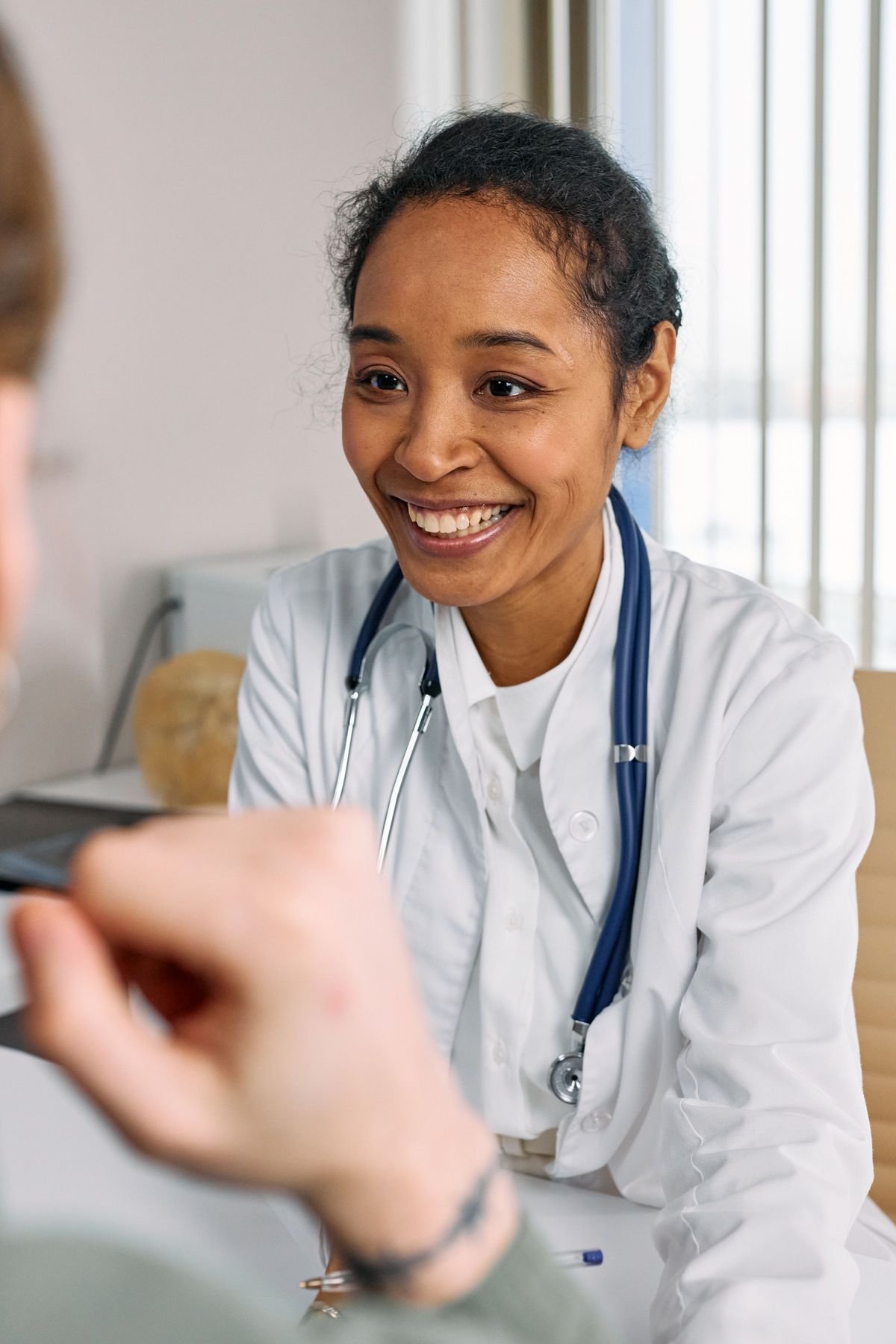A clinician smiling warmly at a patient