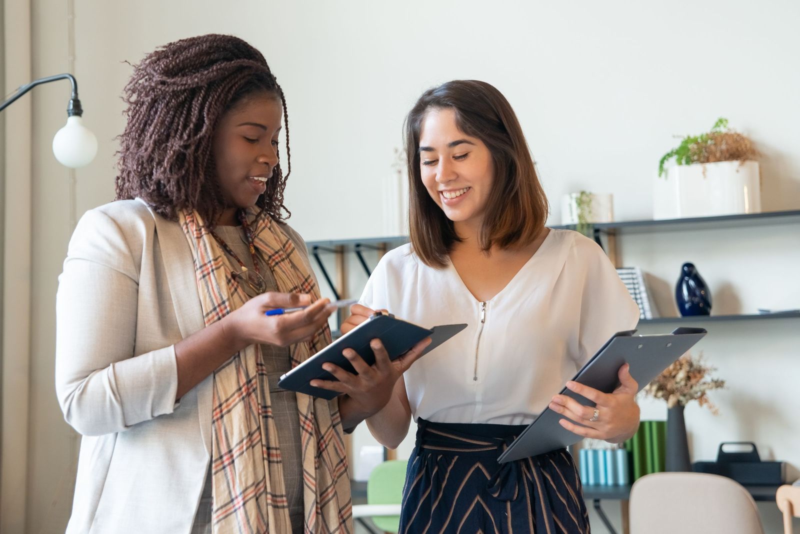 Two colleagues smiling as they review their work